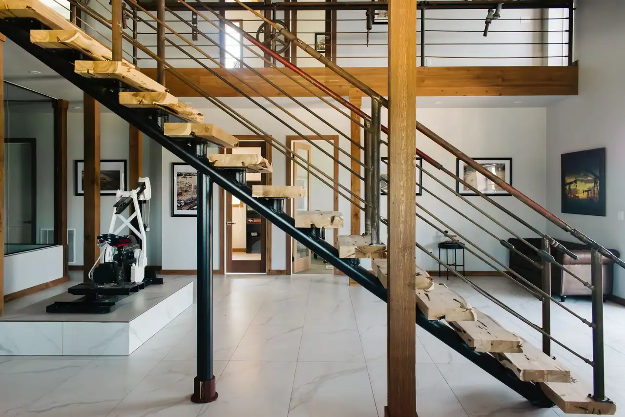 Steel staircase and gym area in a barndominium interior