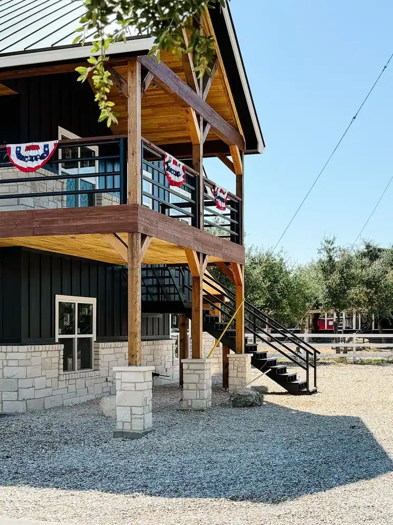 Black party barn with cedar pergola entrance