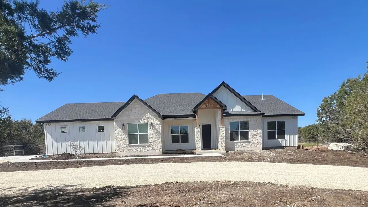 Finished front of a new custom home Ridge Rock built in Dripping Springs, with board-and-batten siding and stone