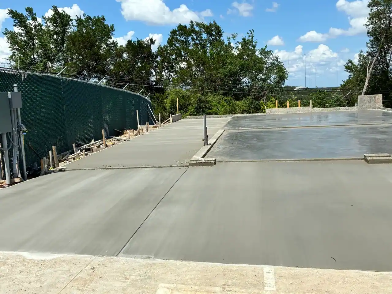 Freshly poured concrete slab with forms and plumbing penetrations at a church building project