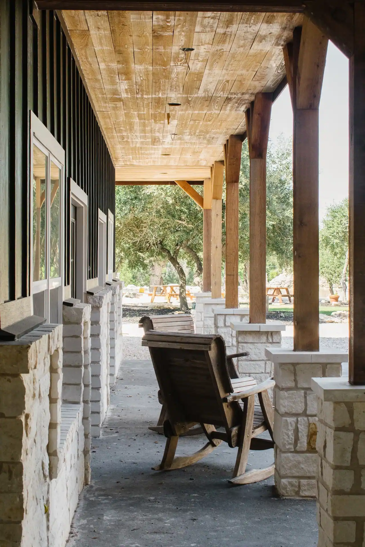 Covered porch with cedar posts overlooking oak trees
