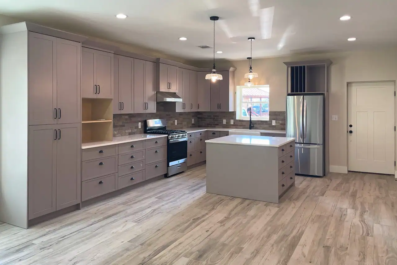 Kitchen with gray shaker cabinets, a center island, and pendant lights in a San Marcos barndominium