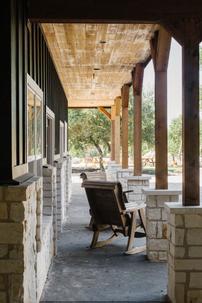 Covered porch with cedar posts overlooking oak trees