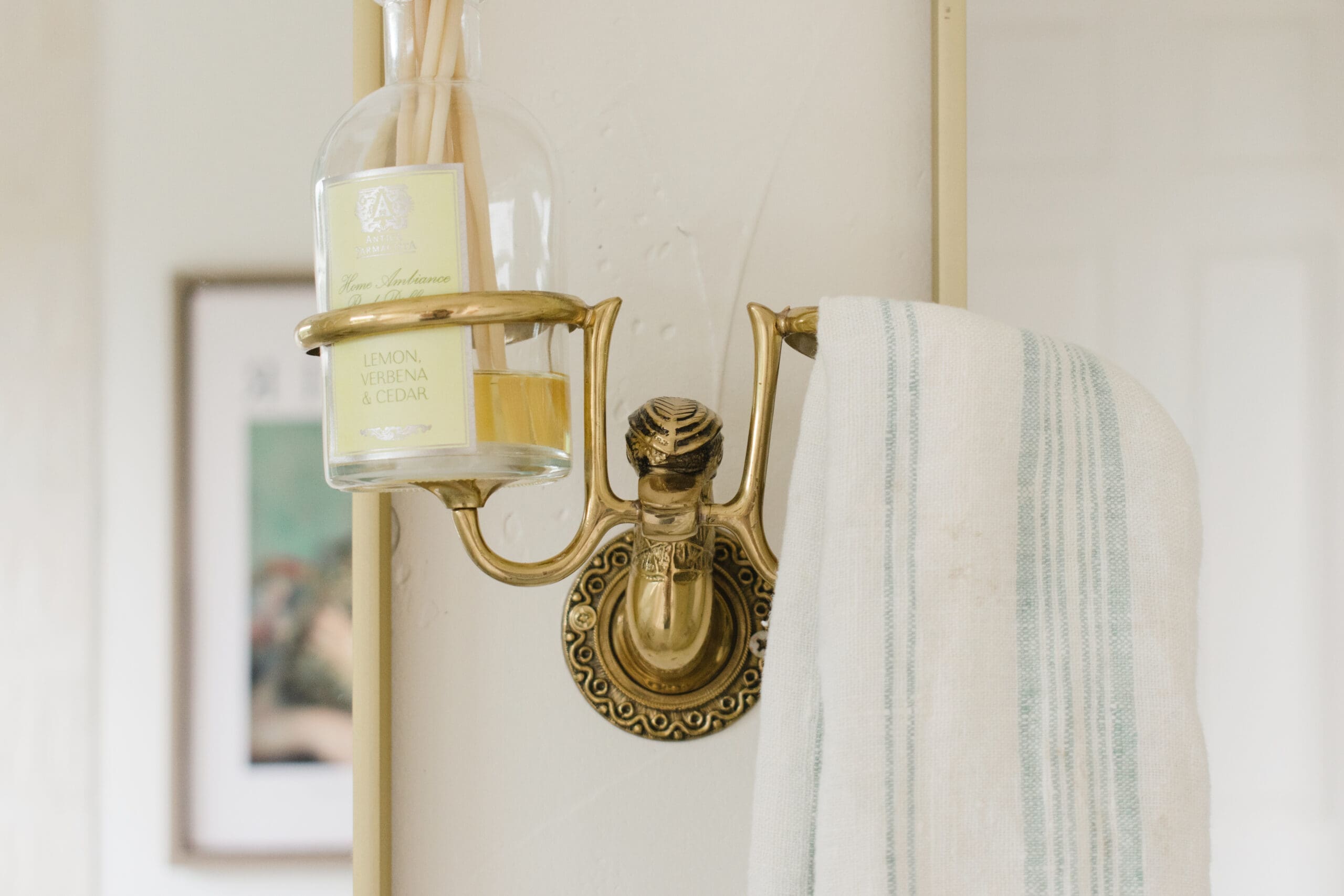 Antique brass sconce against marble in a custom bathroom