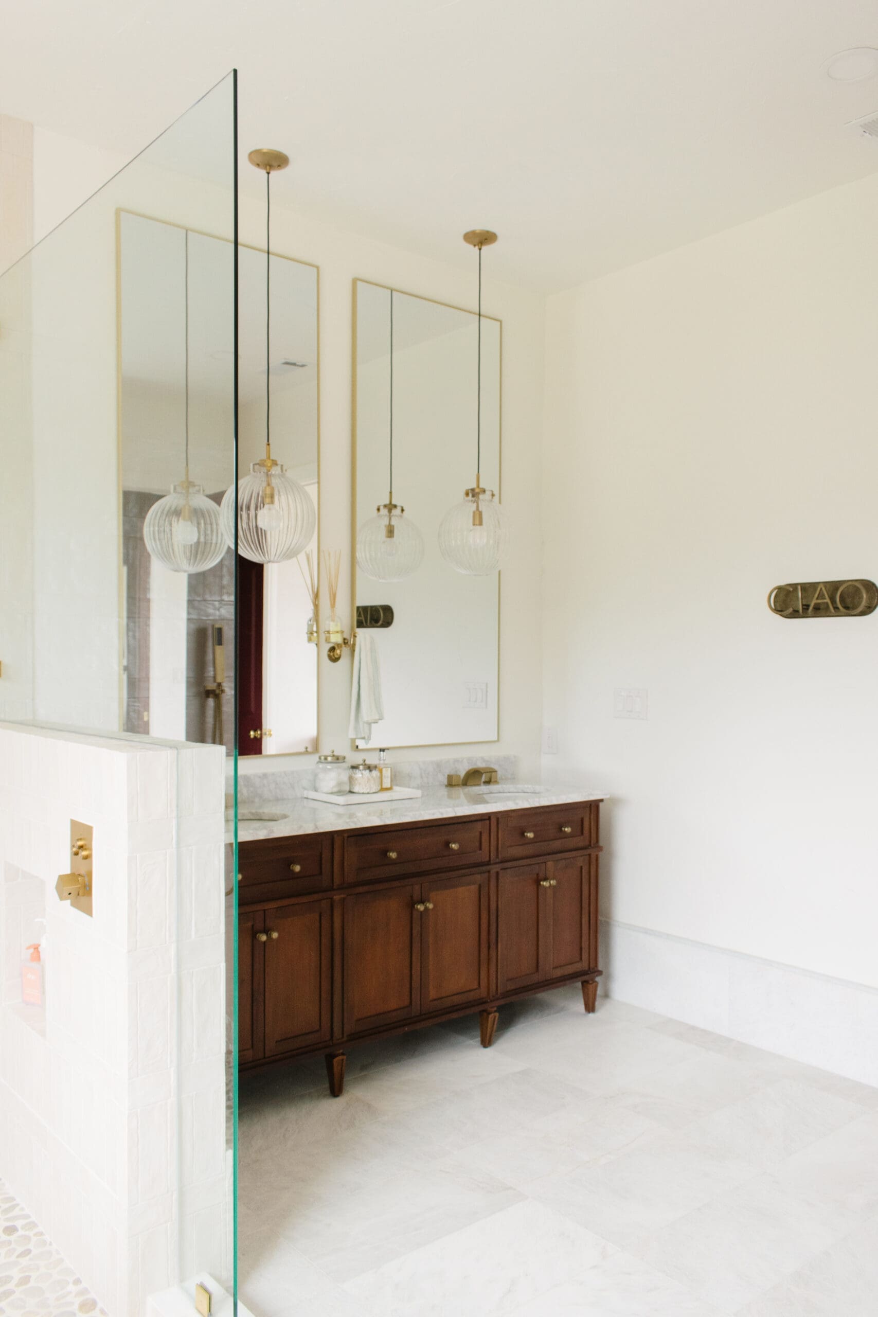 Vanity mirror and brass sconces in a remodeled Hill Country bathroom