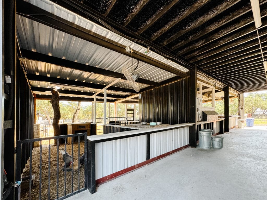 Open-air custom livestock barn with stalls and a wash area