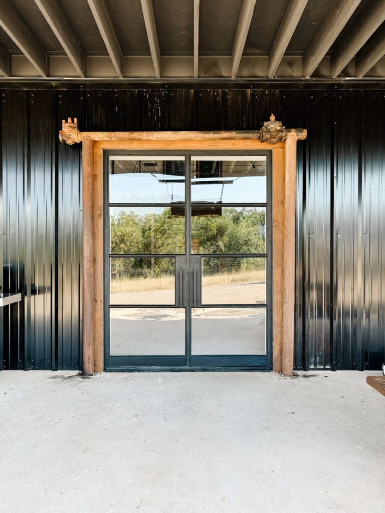 View through a livestock barn breezeway with pipe gates