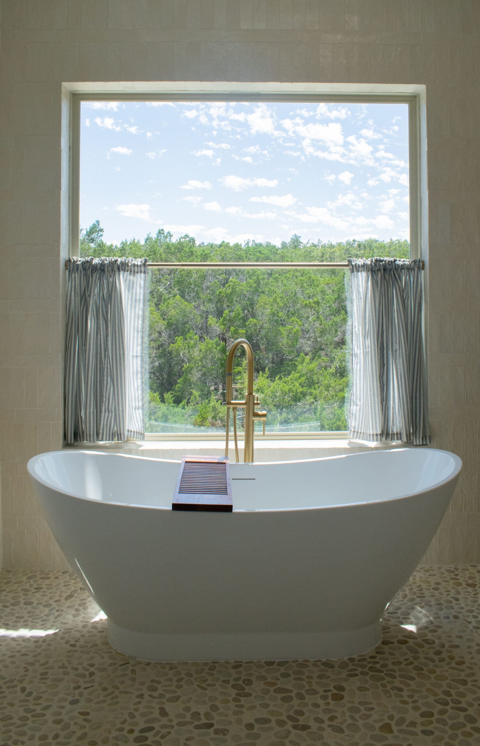 Soaking tub with brass filler overlooking Hill Country trees