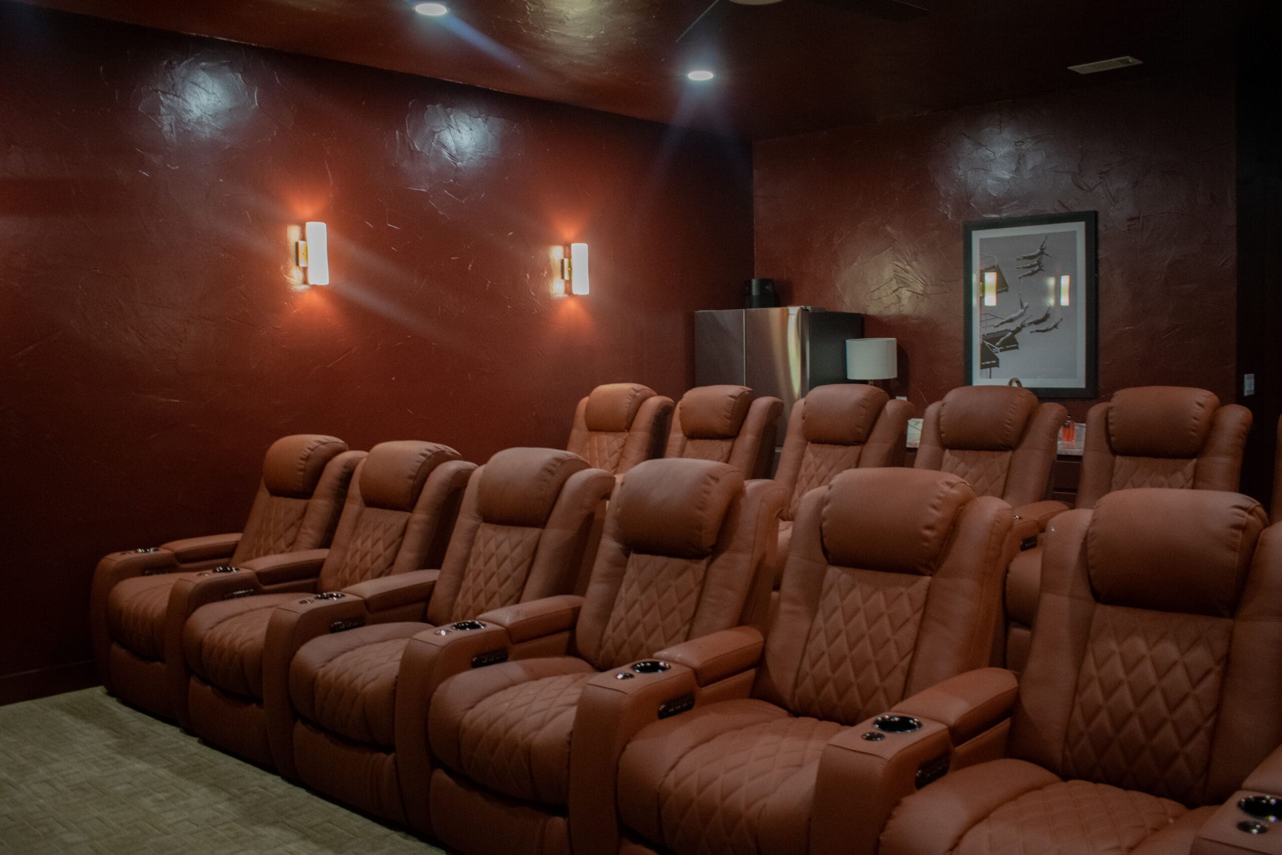 Custom home theater with quilted leather recliners and wall sconces