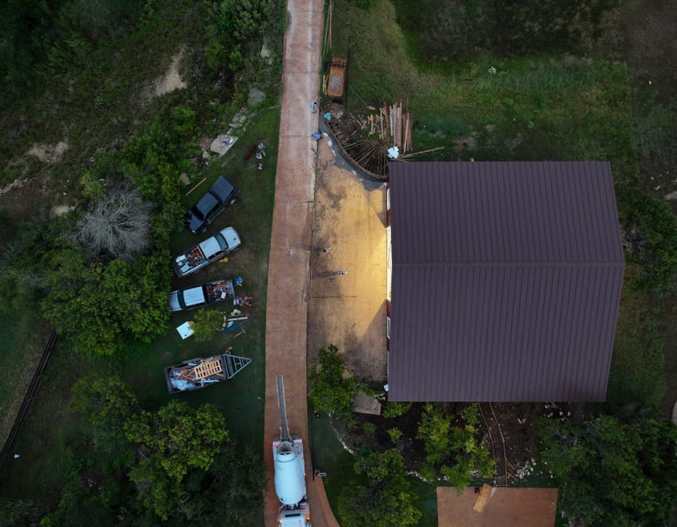 Overhead view of a fresh concrete apron poured beside a metal building