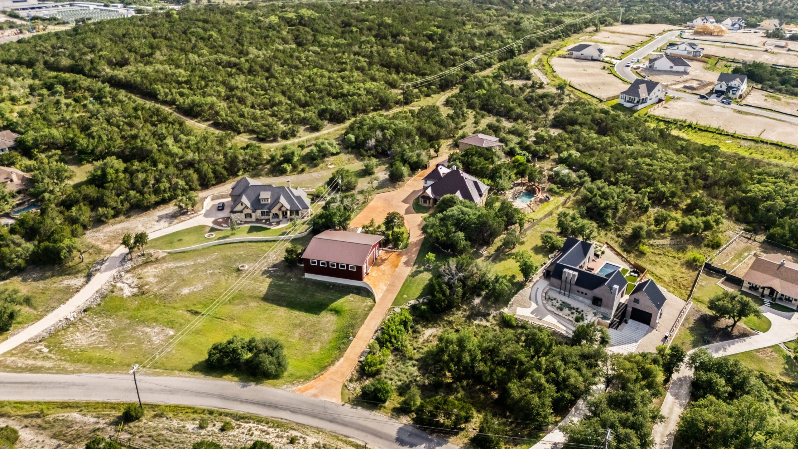 Aerial view of custom homes on tree-covered lots in the Texas Hill Country