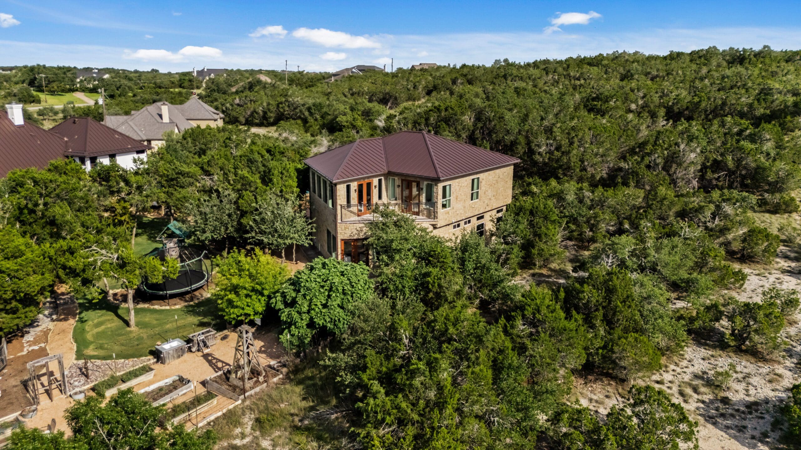 Ridge Rock stone guest house placed among dense Hill Country trees
