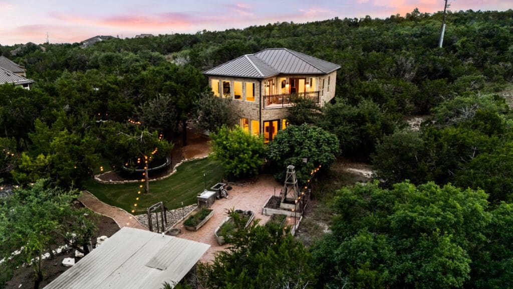 Two-story Canyonwood casita guest house lit at dusk among oak trees