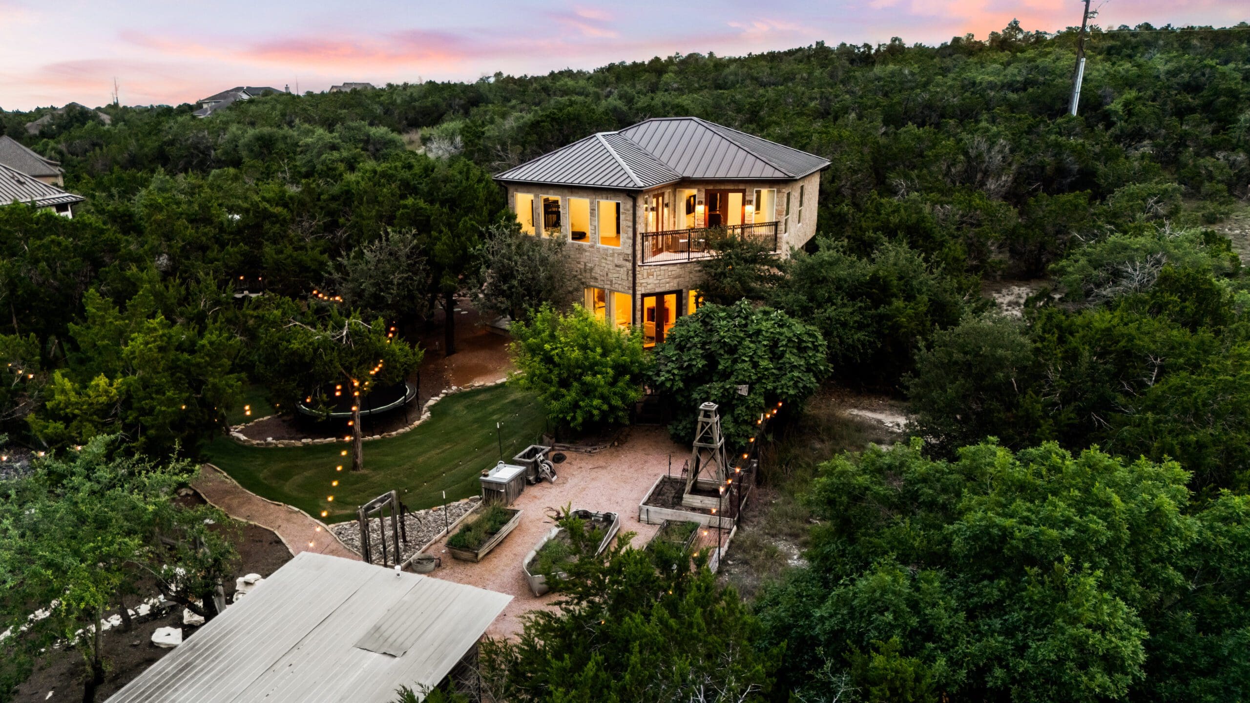 Two-story casita lit at night with landscape path lighting
