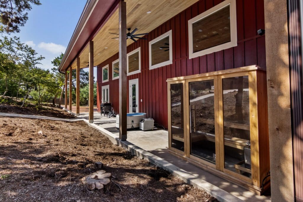 Walkway along a red casita with glass patio doors under a covered porch