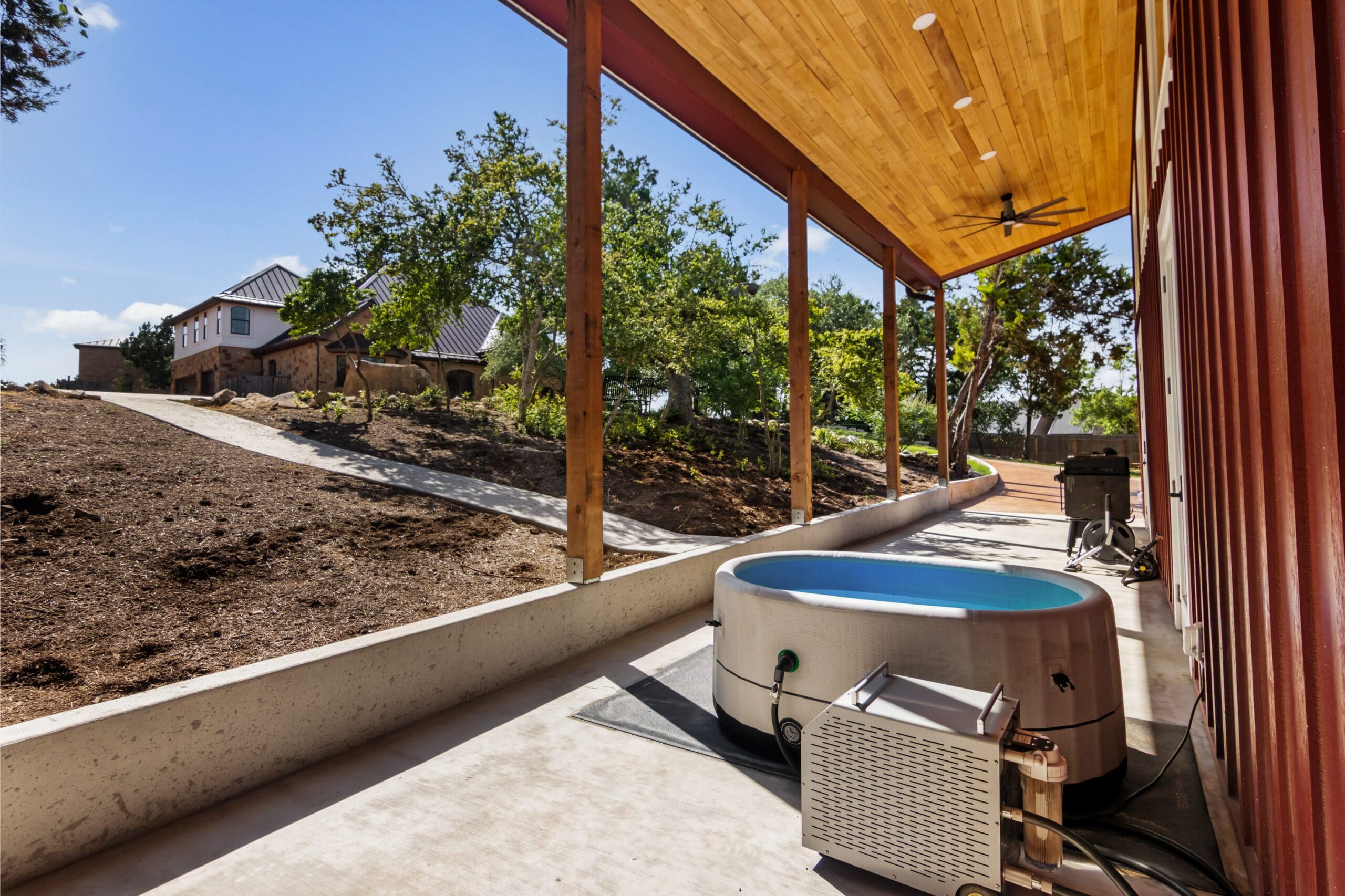 Covered porch with stock tank pool at a casita under construction