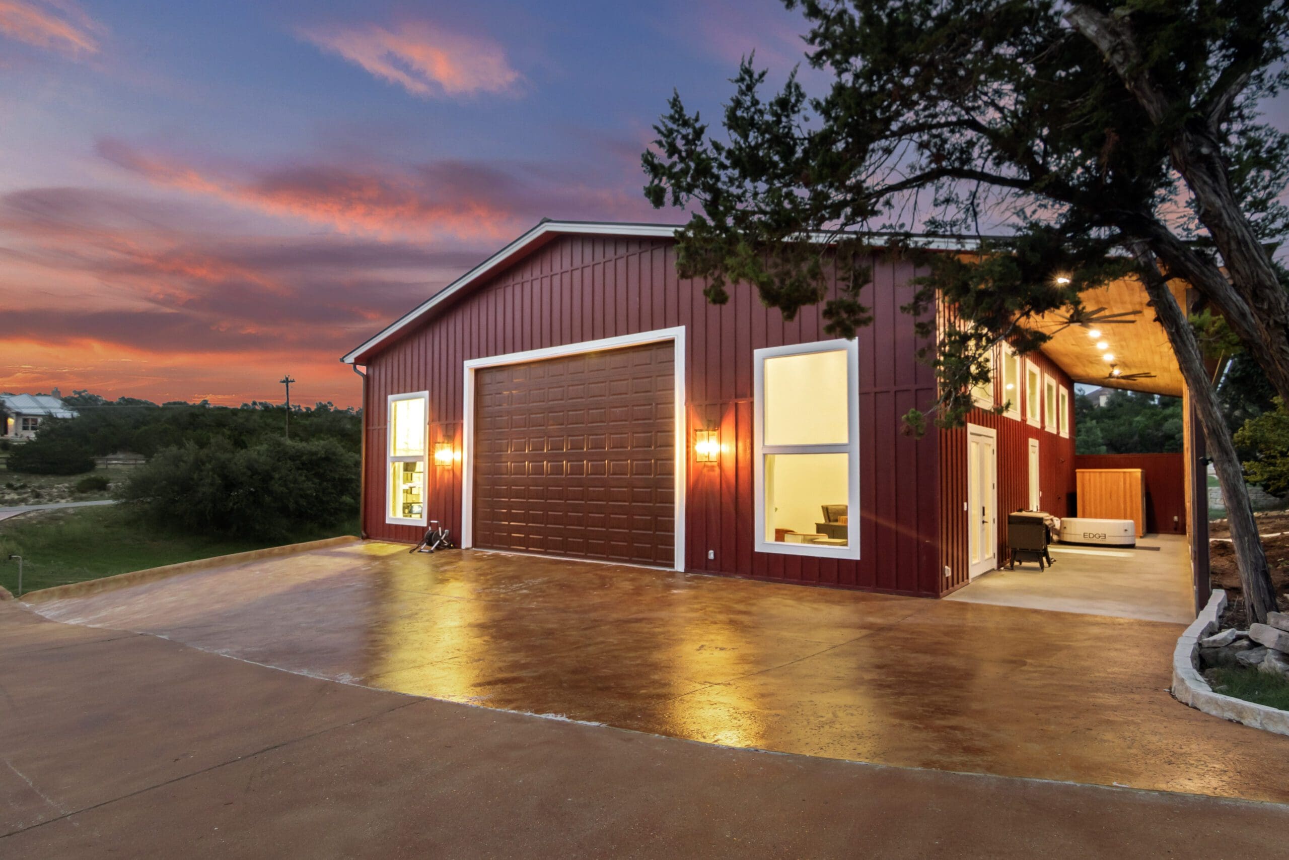 Red barn shop lit at dusk on a Hill Country property
